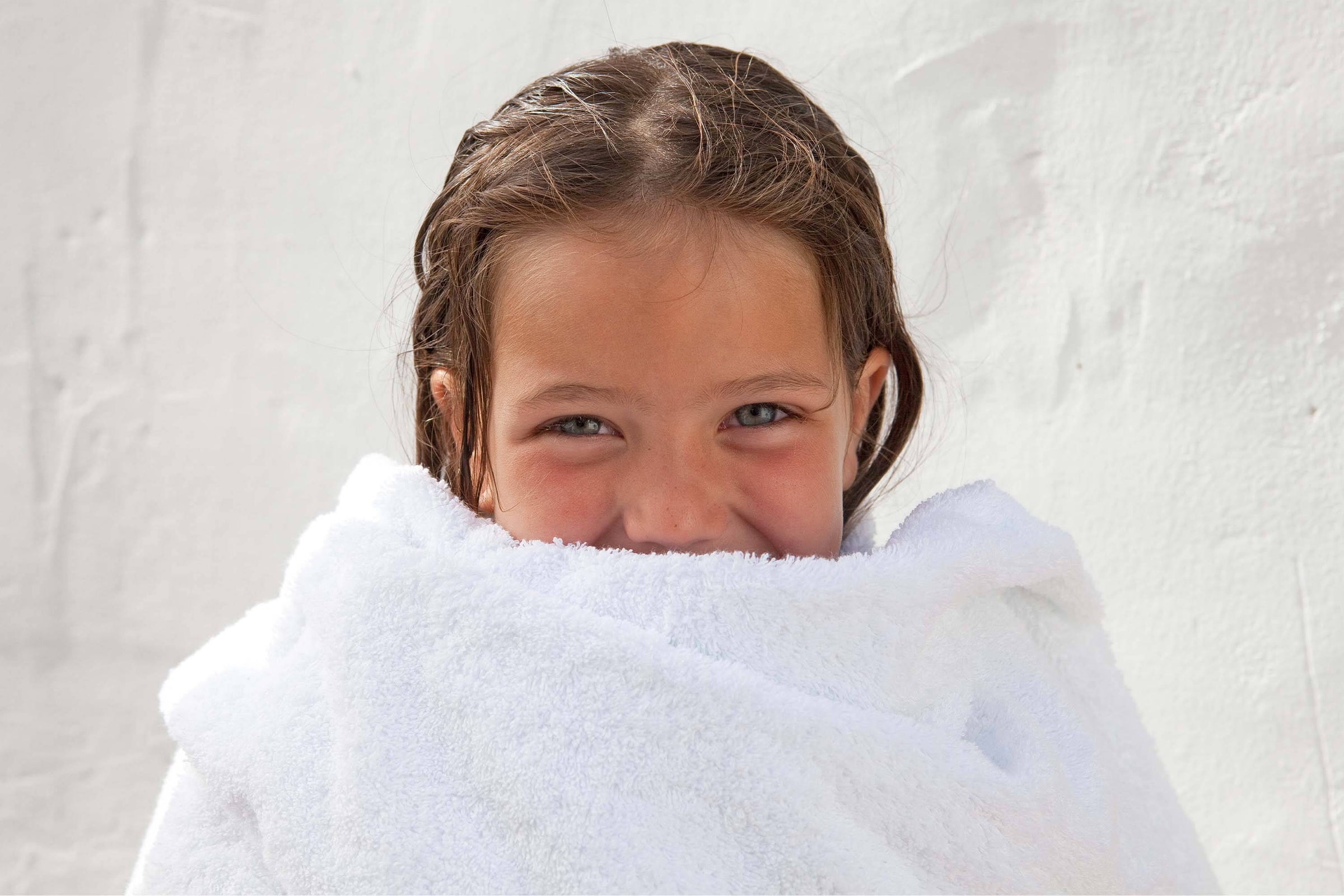 Little girl wrapped in white cotton towel